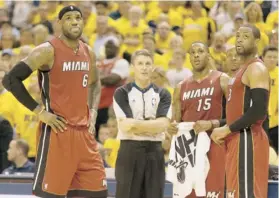  ??  ?? LeBron James (6), Mario Chalmers (15) y Dwyane Wade observan la repetición de una jugada del primer partido de la serie.