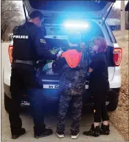  ?? MEGAN DAVIS/MCDONALD COUNTY PRESS ?? Anderson Police Chief Seth Daniels helps two young children select gifts during the department’s second annual Traffic Stop Santa event on Wednesday, Dec. 20.