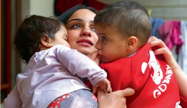  ?? — AFP ?? TEARS DRY UP: Islam Maytat from Morocco with her two children in Qamishli in northern Syria after she escaped from Daesh territory following three traumatic years.