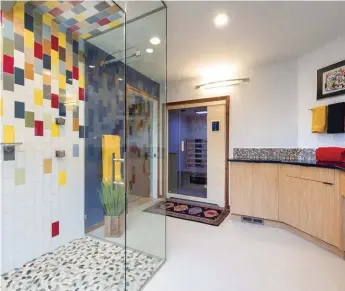  ??  ?? SMALL MOSAIC TILES CREATE THE BACKSPLASH, WHICH IS CARRIED AROUND THREE WALLS OF THE BATHROOM. LARGER SUBWAY TILES IN THE SHOWER MIMIC THE VIBRANT COLORS OF THE SMALL MOSAIC BACKSPLASH.