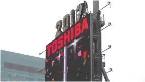  ?? (Reuters) ?? WORKERS PREPARE the New Year’s Eve numerals above a Toshiba sign in Times Square in Manhattan.