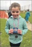  ?? ?? Tia McKinnon with her bronze race medal and silver overall XC League medal.