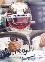  ??  ?? Mercedes’ Lewis Hamilton prepares in the paddock, ahead of the qualifiers for the Bahrain GP. — AFP