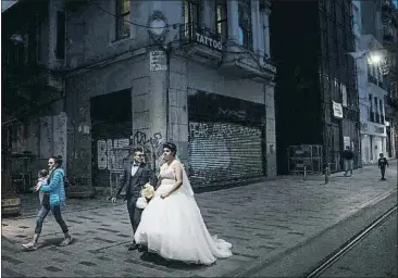  ?? CHRIS MCGRATH / GETTY ?? Una pareja de recién casados pasea por la calle Istiklal de Estambul