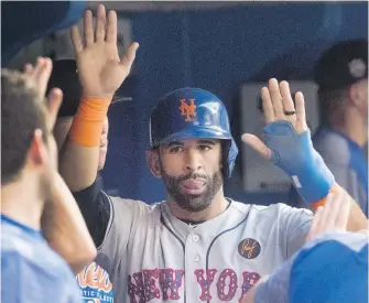  ?? FRED THORNHILL, CP ?? Mets teammates congratula­te Jose Bautista in the dugout after his fifth-inning run.