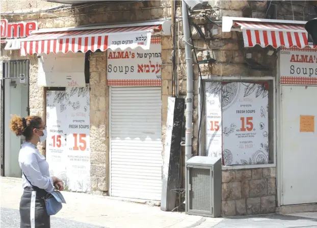  ?? (Marc Israel Sellem/The Jerusalem Post) ?? A CLOSED RESTAURANT in Jerusalem. Government plans vary concerning what needs to be done next.