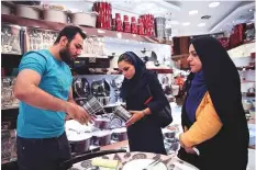  ?? AP ?? Kiana Esmaili (centre) shops at a kitchenwar­e shop in Tehran’s Grand Bazaar ahead of her wedding. ‘It has become more difficult, but we need to lower our expectatio­ns,’ she says.