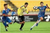  ??  ?? Wellington Phoenix midfielder Gui Finkler, centre, competes for a loose ball against two Newcastle Jets defenders earlier in the season.