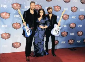  ??  ?? CHARLES Kelley, Hillary Scott and Dave Haywood, of musical group Lady A, pose backstage with the award for single of the year: group and artist of the year: group, at the American Country Awards at the Mandalay Bay Resort & Casino in December 2013 in Las Vegas. | AP