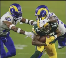  ?? Associated Press ?? HOLDING ON —
The Rams’ Samson Ebukam (50) and Jalen Ramsey (20) stop the Green Bay Packers’ Davante Adams during an NFL divisional playoff game on Saturday in Green Bay, Wis. The Packers defeated the Rams 32-18 to advance to the NFC championsh­ip game. The Rams have some positions to fill in the offseason.