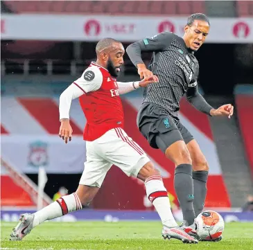  ?? AFP ?? Liverpool’s Virgil van Dijk, right, vies with Arsenal’s Alexandre Lacazette during the match at the Emirates Stadium.