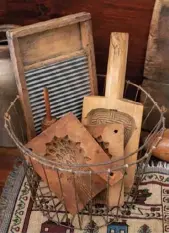  ??  ?? Above right: Antique wooden molds and an old-fashioned washboard mingle in a wire basket in the kitchen.