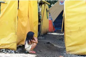  ?? AFP FOTO ?? DISPLACED.
This photo taken on Oct. 26, 2017 shows a young evacuee displaced by the Marawi crisis, sitting among tents in an evacuation center in Balo-i, Lanao del Sur.
