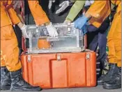  ?? ULET IFANSASTI/GETTY ?? Officials display part of Lion Air Flight JT 610’s “black box,” which is actually orange, on Thursday in Jakarta, Indonesia.