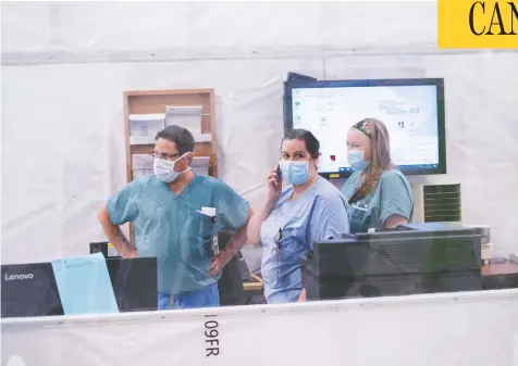  ?? PAUL CHIASSON / THE CANADIAN PRESS ?? Employees work at a nursing station in a temporary addition to the Hôpital de Verdun in Montreal on Wednesday. Travel data shows that 373 cases of the novel coronaviru­s in Quebec came from the United States and the province reported zero cases connected to travel from China.