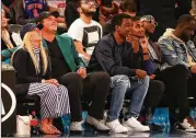  ?? MIKE LAWRIE / GETTY IMAGES ?? Masters champion Patrick Reed, with wife Justine (left) and comedian Chris Rock along with other celebritie­s, wears his green jacket to the Knicks-Cavs game Monday at Madison Square Garden.