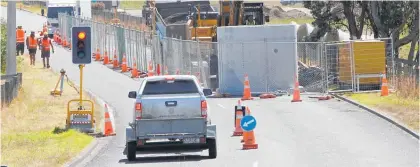  ?? Photo / Stuart Munro ?? Traffic lights and heavy machinery signal a start of major work on Mill Rd in Castleclif­f.