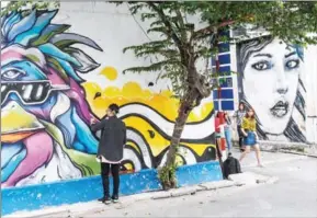  ?? HOANG DINH NAM/AFP ?? Dan Nguyen, a California-born Vietnamese artist who moved to Ho Chi Minh City about five years ago, works on his graffiti at ‘3A Station’, a graffiti hub and street art area in Ho Chi Minh City.