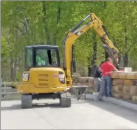  ?? DAVID JACOBS/SDG ?? NEWSPAPERS
Added touches were recently put into place at the site of an old bridge that was rebuilt last year in Richland County. Crew members returned to North Lake Park to install capstones along the top of the historic bridge had reopened late in 2020 following a more than three-month constructi­on project. Last year, team members were able to use recycled stones from the original bridge to use in the new bridge that was nearing its re-opening as Christmas 2020 approached. At the time of the reopening, winter weather had arrived so the capstone installati­on took place in spring 2021 as shown April 27. The bridge is only a short distance from the Richland B&O Bike Trail used by Shelby area visitors.