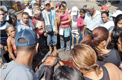  ??  ?? La víctima. El cuerpo de Patinez Gómez, con una herida mortal en su pecho, ayer, ante el estupor de la gente.