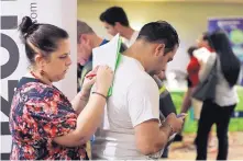  ?? LYNNE SLADKY/ASSOCIATED PRESS, FILE ?? Loredana Gonzalez, of Doral, Fla., fills out a job applicatio­n at a JobNewsUSA job fair in Miami Lakes, Fla. Hiring continued to grow in October, bringing wages up, as well.