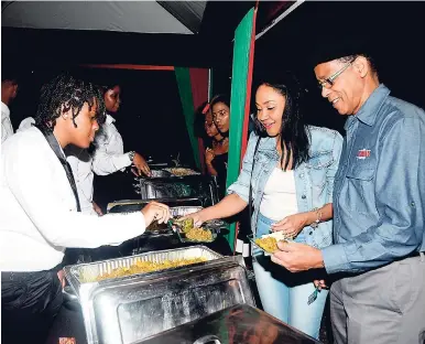 ??  ?? Chairman of JMMB Group, Archibald Campbell, and Fornia Young dig right into the nyammings.