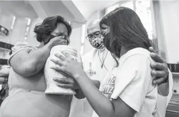  ?? (Jire Carreon/ABS-CBN News photo) ?? Fr. Flavie Villanueva condoles with family members of alleged extra-judicial killing victims during a prayer service and the turnover of urns in Quezon City on September 28, 2022. The administra­tion of President Ferdinand “Bongbong” Marcos, Jr. launched a fresh drug campaign anchored on human rights and drug use deterrence, vowing that they would catch bigger illegal drug traders.