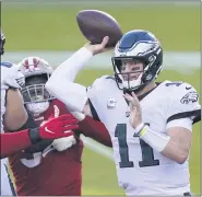  ??  ?? Eagles quarterbac­k Carson Wentz, right, unloads a pass ahead of the San Francisco 49ers rush during the first half Sunday night in Santa Clara, Calif.