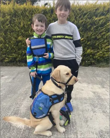  ??  ?? Ryley Mahe with his younger brother Oren and his assistance dog, Cookie.