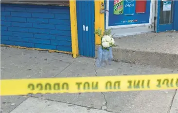  ?? BALTIMORE SUN FILE ?? Flowers were placed at the entrance of Kim’s Deli after Carmen Rodriguez, 36, was shot and killed inside the store on Dec. 22, 2019.