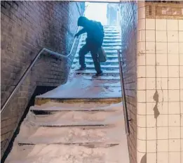  ?? BRITTAINY NEWMAN/AP ?? A man carefully walks down snow-covered subway stairs Saturday in the Bushwick section of the Brooklyn borough of New York City during a winter storm.