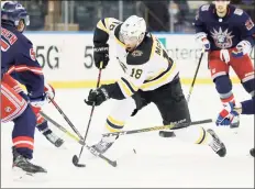  ?? Sarah Stier / Getty Images ?? The Bruins’ Greg McKegg, right, controls the puck as the Rangers’ Ryan Lindgren defends during the first period on Sunday in New York.