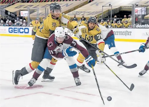  ?? Ethan Miller, Getty Images ?? The Golden Knights’ Nicolas Roy, left, the Avs’ J.T. Compher, center, and the Knights’ Ryan Reaves chase the puck after a faceoff in the second period on Sunday in Las Vegas.