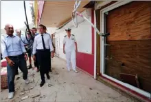  ?? The Associated Press ?? French President Emmanuel Macron inspects damaged houses destroyed by Irma during his visit in the Caribbean island of St. Martin on Tuesday. Eleven people were killed on the French side of the island and four more in St. Maarten on the Dutch side,...