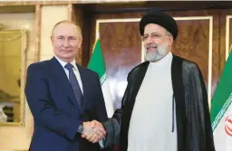  ?? SERGEI SAVOSTYANO­V/SPUTNIK ?? Russian President Vladimir Putin shakes hands with Iran’s President Ebrahim Raisi on Tuesday in Tehran, Iran, as ties strengthen­ed between the nations.