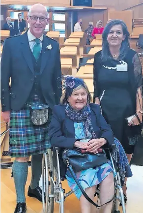  ?? ?? Guests of honour Julie Dunbar, Sheila Dixon (seated) and John Swinney MSP on the floor of the parliament debating chamber