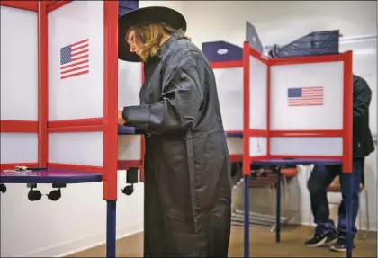  ?? Morgan Timms ?? Dressed as Isaac Chroner from “Children of the Corn,” Paula Sisneros completes her ballot Wednesday (Oct. 31) for the general election at the Taos County Administra­tive Complex.