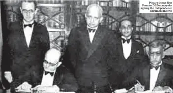  ??  ?? Picture shows first Premier D.s.senanayake signing the Independen­ce document in 1948