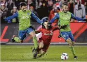  ?? Nathan Denette / Canadian Press ?? Toronto FC forward Sebastian Giovinco, center, is feeling the squeeze after being sandwiched by the Sounders’ Cristian Roldan, left, and Tyrone Mears.