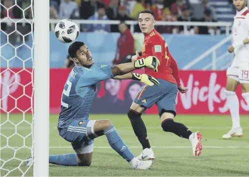  ??  ?? 0 Iago Aspas of Spain backheels a late equaliser past Monir El Kajoui of Morocco to earn Spain a 2-2 draw and secure top spot in Group B.