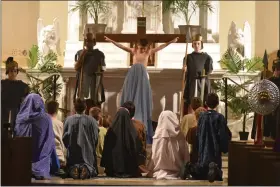  ?? BARRY TAGLIEBER — FOR MEDIANEWS GROUP ?? Anthony Sabatino portrays Jesus on the cross as Holy Family School class members gather around him at St. Ann Catholic Church during the school’s presentati­on of The Living Stations of the Cross.