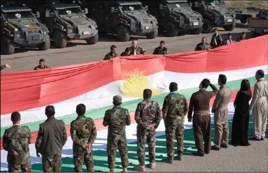  ??  ?? أرشيفية لعناصر من البيشمركه يرفعون علم كردستان