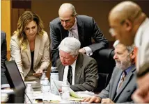  ?? BOB ANDRES / BANDRES@AJC.COM ?? Claud “Tex” McIver (center) is surrounded by attorneys as they review questions from the jury for the McIvers’ personal masseuse, Annie Anderson, during trial at the Fulton County Courthouse on Thursday.