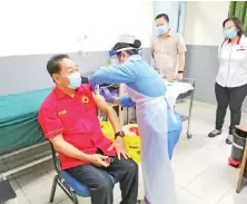  ??  ?? Wong receives the Covid-19 vaccine from nurse Winnie Wartie at Lanang Health Clinic.