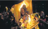  ?? Picture: AFP/ WIKUS DE WET ?? FIERY PROTEST: Zimbabwean­s in Hillbrow, Johannesbu­rg, burn a shirt of the ruling Zanu-PF party