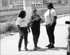  ?? AP PHOTO/LYNNE SLADKY ?? In this July 24 photo, Ivette Naida (center) talks with social worker Elisha Ekowo, left, and Chevel Collington, right, both of the IDEA Exchange, in Miami.