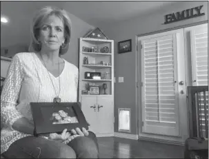  ?? The Associated Press ?? FAMILY: Mary Ann Mendoza holds a framed picture of herself and her son, Brandon Mendoza, on Thursday at her home in Mesa, Ariz. Families who have lost loved ones to crimes committed by immigrants are praising President Donald Trump’s announceme­nt this...