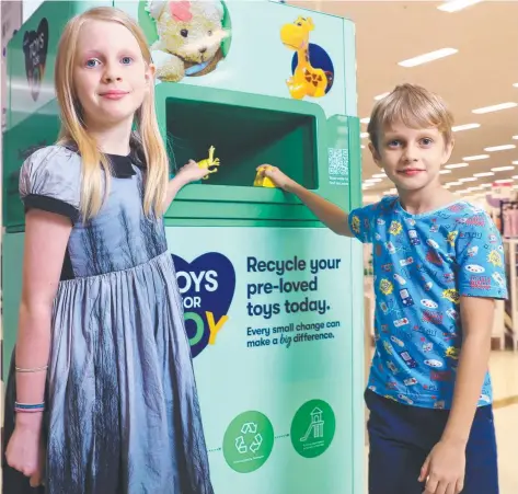  ?? ?? Big W has begun a national campaign to recycle preloved toys, with a recycling centre at the front of its Earlville store. Cairns siblings Elizabeth Evans, 10, and Gilles Evans, 7, place some toys into the basket. Picture: Brendan Radke
