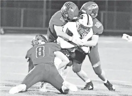  ??  ?? Homestead's Aidan Reis is smothered by Slinger defenders on Friday night. The Owls had two defensive stands in the final 2 minutes to seal the 20-14 victory.