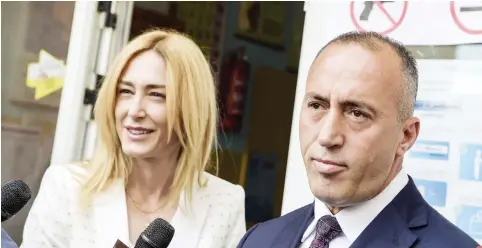  ??  ?? Ramush Haradinaj, prime minister candidate and leader of the Alliance for Future of Kosovo (AAK), speaks to the press next to his wife Anita after voting at a polling station in Pristina on Sunday. (AFP)